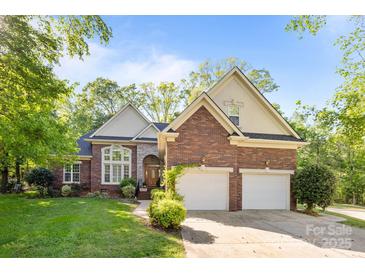 Charming two-story brick home with attached two-car garage and manicured lawn at 7815 Scottsburg Ct, Mint Hill, NC 28227