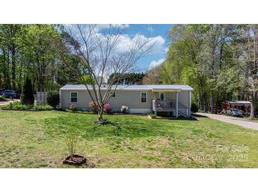 Charming home with a metal roof and a lovely front yard, set against a backdrop of lush trees at 8705 Carroll St, Hickory, NC 28601