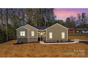 A single-story home showcasing a well-maintained lawn, fresh landscaping, and a charming entryway at 9165 Cherokee Dr, Hickory, NC 28601