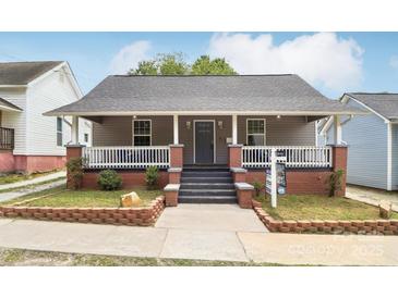 Charming single-story home with a cozy front porch and well-maintained landscaping at 113 Mcgill Nw Ave, Concord, NC 28025