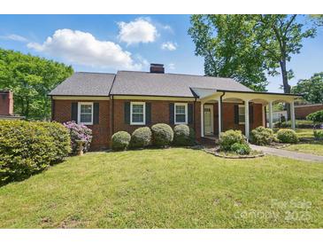 Charming brick home with a well-maintained front lawn and covered porch, exuding curb appeal at 113 S College St, Monroe, NC 28112