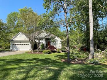 Landscaped front yard and charming exterior of home with attached two-car garage and mature shade trees at 121 General Pemberton St, Stanley, NC 28164