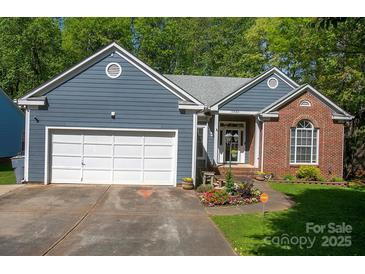 Charming single-story home with blue siding, brick accents, and a well-manicured front yard at 12435 Mallard Dr, Charlotte, NC 28269