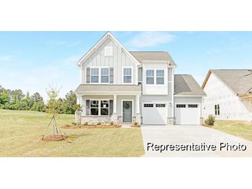Charming two-story home with stone accents, a welcoming porch, a two-car garage, and manicured front lawn at 2416 Morgan Hills Dr # 297P, Albemarle, NC 28001