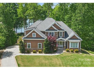 Beautiful two-story home with stone accents and a well-manicured lawn, nestled amongst mature trees at 2501 Mt Isle Harbor Dr, Charlotte, NC 28214