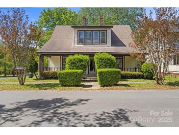 Charming home featuring a dormer window and inviting front porch, nestled amongst manicured trees at 510 S Carolina Ave, Spencer, NC 28159
