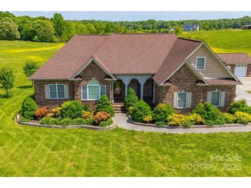 Charming brick home featuring a lush, landscaped front yard with inviting curb appeal at 514 Clover Leaf Rd, Marshville, NC 28103