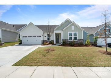 Charming single-story home featuring a well-manicured lawn, stone accents and an attached two-car garage at 6145 Holland St, Fort Mill, SC 29707
