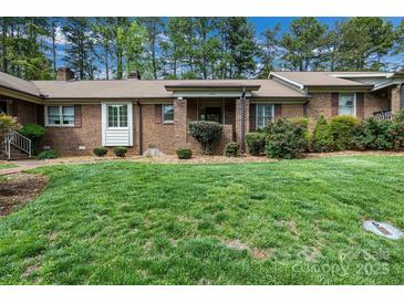 Charming brick home with lush green lawn, mature trees, and inviting front entrance at 704 Colby Cir, Salisbury, NC 28147
