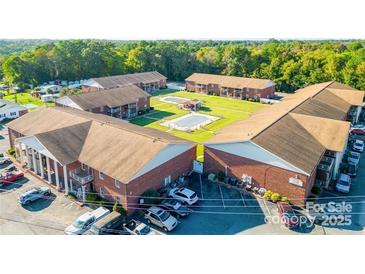 A beautiful aerial view of a brick apartment complex with a pool and well-maintained landscaping, creating a peaceful atmosphere at 103 Carriage House Dr, Kannapolis, NC 28081