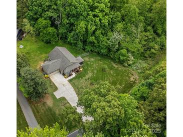 Aerial view of a charming single-Gathering home nestled among lush green trees with a long driveway and large lot at 10340 Williams Rd, Mint Hill, NC 28227