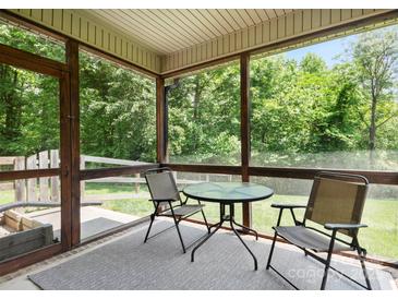 Screened-in patio with table and chairs, perfect for enjoying the outdoors at 10340 Williams Rd, Mint Hill, NC 28227