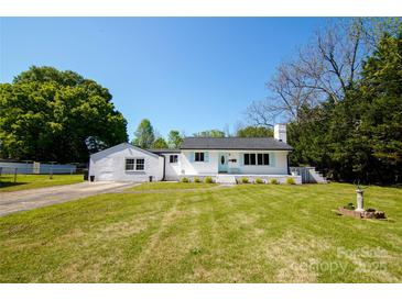 Charming white brick home with blue shutters, lush green lawn, and mature trees at 1081 Deas St, Rock Hill, SC 29732