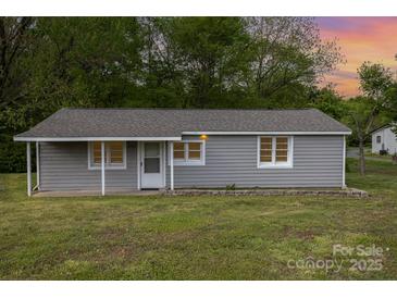 Charming single-story home with gray siding, a covered front porch and well-maintained lawn at 1119 Highway 218 W Hwy, Indian Trail, NC 28079