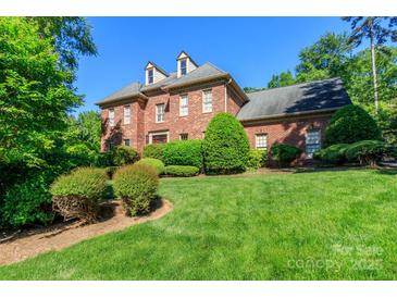Beautiful two-story brick home with lush lawn and mature landscaping at 1233 Weymouth Ln, Charlotte, NC 28270