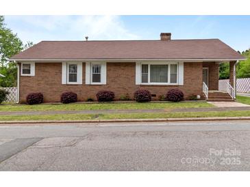 Charming brick home featuring white trim, complementing the landscape at 182 Ryan St, Salisbury, NC 28144
