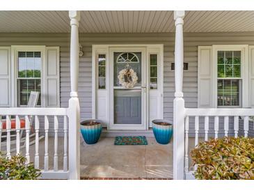 Charming front porch with decorative wreath and vibrant blue potted plants enhances curb appeal at 230 Castle Keep Rd, Salisbury, NC 28146