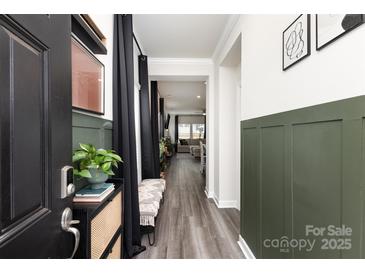 Welcoming entryway featuring modern wood-look floors and stylish wainscoting, leading into a bright, open living space at 330 Hyssop Ct, Fort Mill, SC 29715