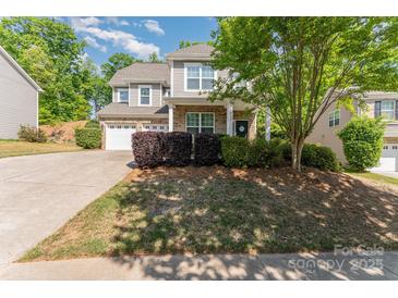 Charming two-story home with a well-manicured lawn, two-car garage, and inviting front porch at 4861 Samuel Pinckney Dr, Belmont, NC 28012