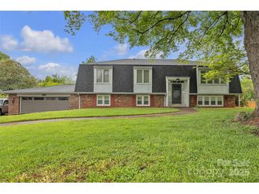 Charming two-story home with brick facade, manicured lawn, and mature trees creates a welcoming curb appeal at 4935 Kennedy St, Hickory, NC 28602