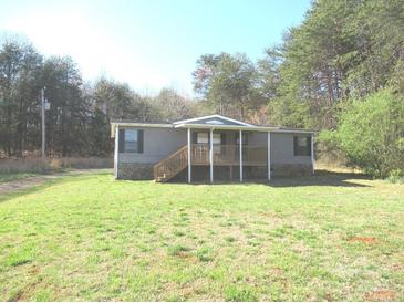 Charming home featuring a covered front porch and surrounded by lush greenery at 5180 Macedonia Church Rd, Vale, NC 28168