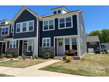 Charming two-story townhome with dark siding, stone accents, manicured lawn, and inviting front porch at 1075 South Point Rd, Belmont, NC 28012