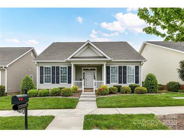 Charming single story home with manicured lawn, dark shutters and covered front porch at 11123 Bailey Park Nature Dr, Cornelius, NC 28031