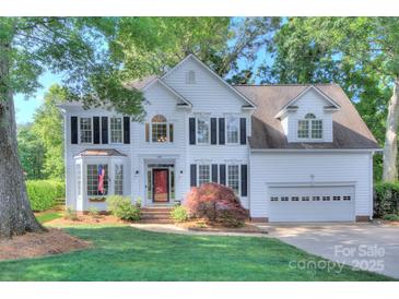 Beautiful two-story white home featuring manicured lawn, brick accents, and attached two-car garage at 1202 Foxfield Rd, Waxhaw, NC 28173
