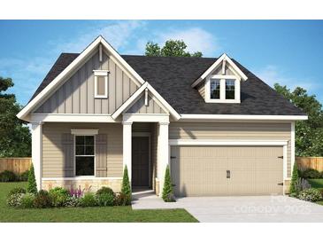 Charming home featuring neutral siding, gabled roof, attached garage and professionally landscaped yard at 1334 Idyllic Ln, Waxhaw, NC 28173