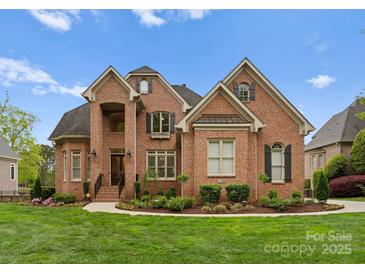 Beautiful brick home with manicured lawn and landscaping creates inviting curb appeal at 13420 Robert Walker Dr, Davidson, NC 28036