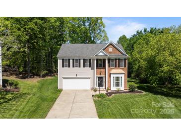 Charming two-story home with brick and vinyl siding, lush green lawn, and a two-car garage at 15002 Strathmoor Dr, Charlotte, NC 28277