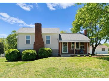 Charming exterior of a home featuring a brick chimney, covered porch with seating, and a well-maintained lawn at 155 Jackson Rd, Salisbury, NC 28146
