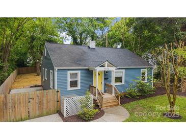 Charming blue home with a welcoming yellow door, gray roof, well-maintained landscaping, and a cozy front porch at 1913 Garibaldi Ave, Charlotte, NC 28208