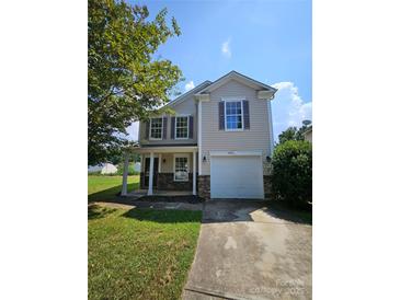 Charming two-story home featuring a covered porch, stone accents, and an attached one-car garage at 2440 Mint Thistle Ct, Charlotte, NC 28269