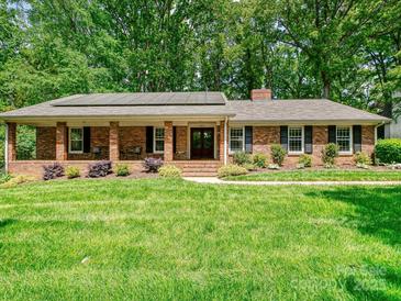 Charming brick home featuring a spacious front yard and inviting covered porch at 301 Glen Oaks Rd, Charlotte, NC 28270