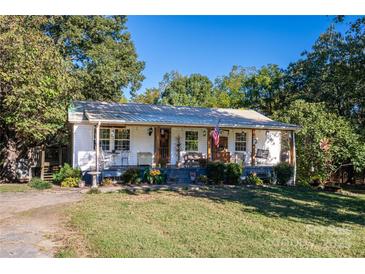 Charming cottage-style home with a welcoming front porch, lush landscaping, and a metal roof at 6312 Bill Ledford Rd, Vale, NC 28168