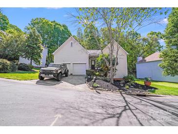 Charming home with an attached garage and beautifully landscaped front yard at 13817 Kings Carriage Ln, Charlotte, NC 28278