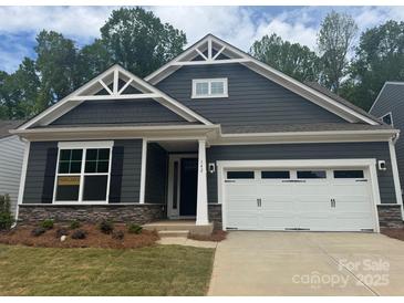 Charming craftsman-style home featuring a two-car garage, stone accents, and eye-catching gable details at 142 Prestwick Way # 18, Mooresville, NC 28115