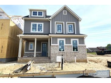 Charming two-story home with a brick foundation, gray siding, and a welcoming covered front porch at 19044 Newburg Hill Rd, Davidson, NC 28036