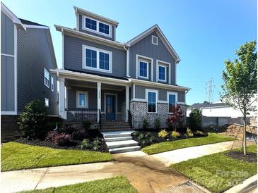 Charming gray two-story home with white trim, manicured lawn and inviting front porch and tasteful landscaping at 19044 Newburg Hill Rd, Davidson, NC 28036