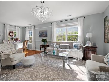 Bright and airy living room featuring hardwood floors, neutral tones, and a chandelier at 281 Loch Stone St, Fort Mill, SC 29715