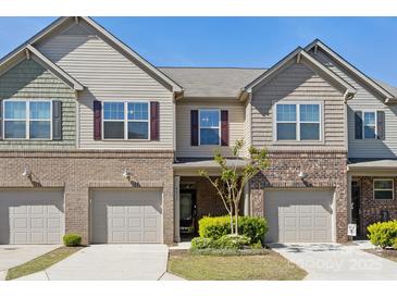 Townhome exterior with brick accents, gray siding, and attached garages at 4011 Black Walnut Way, Indian Land, SC 29707