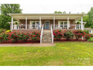 Charming brick home featuring a large porch with white columns and lush red rose bushes at 5840 Shirley Rd, Fort Lawn, SC 29714