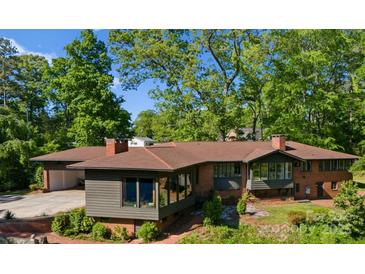 Expansive brick home featuring a covered parking area and plentiful trees at 916 E Park Dr, Lincolnton, NC 28092