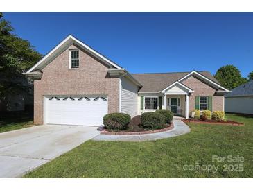 Charming brick home with a well-manicured lawn, attached garage, and inviting front entrance at 1002 Christobal Ct, Indian Trail, NC 28079