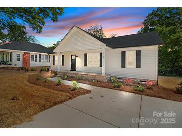 Charming one-story home with white siding, black shutters, and a cozy front porch at 112 Cleveland Ave, Albemarle, NC 28001