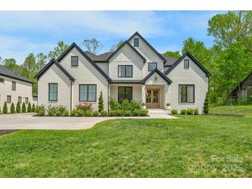 Stunning two-story brick home boasts black trim, a manicured lawn, and meticulous landscaping at 2165 Country Club Rd, Lincolnton, NC 28092