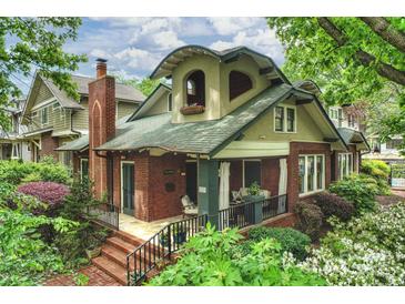Charming brick home with a covered front porch and lush landscaping, surrounded by mature trees, in a desirable neighborhood at 2229 Kenmore Ave, Charlotte, NC 28204