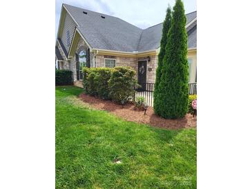 Charming home featuring a stone facade, manicured lawn, and tasteful landscaping for enhanced curb appeal at 2355 Villa Oaks Ct, Gastonia, NC 28054