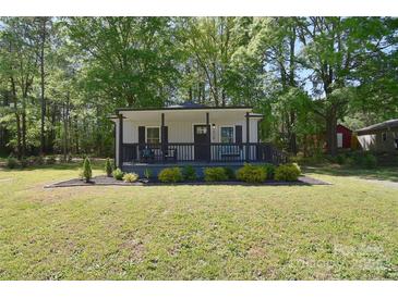 Charming single-story home with a inviting front porch, manicured lawn, and mature trees providing ample shade at 315 N Kimmons St, Landis, NC 28088
